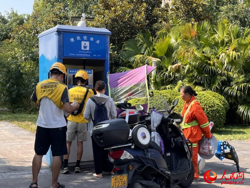 9月5日，正在“0011”號(hào)便民飲水點(diǎn)排隊(duì)接水的市民。周小平攝